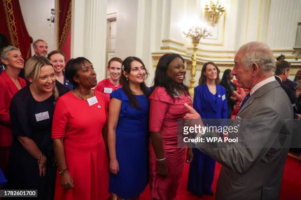 Britain's King Charles III speaks with members of the NHS Choir after they sung for him on his birthday, during a meeting with nurses and midwives to...