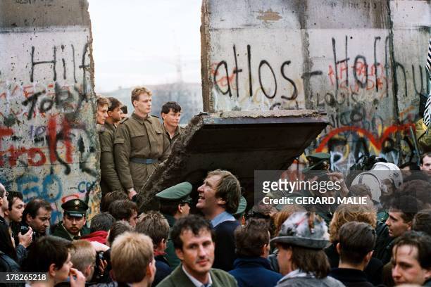 West Berliners crowd in front of the Berlin Wall early 11 November 1989 as they watch East German border guards demolishing a section of the wall in...