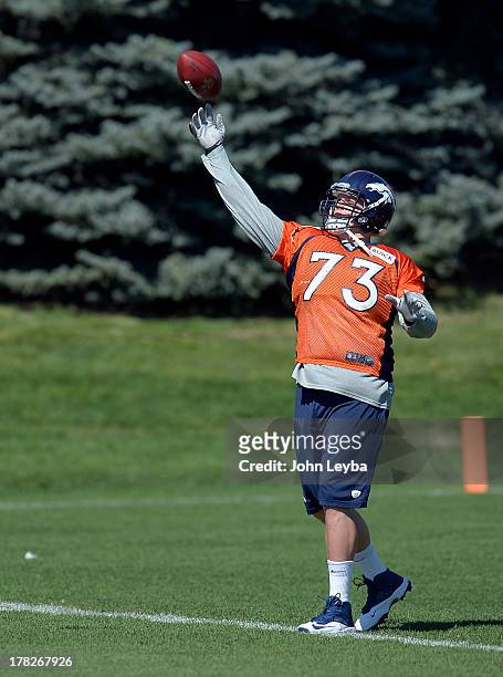 Denver Broncos guard Chris Kuper throws a pass during practice August 28, 2013 at Dove Valley.