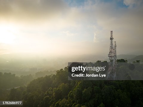 City telecommunication tower in greenery and sunrise, aerial view City telecommunication tower in greenery and sunrise, aerial view