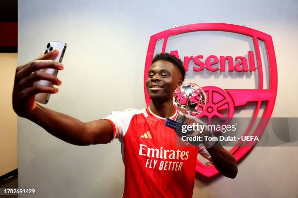 Bukayo Saka of Arsenal takes a selfie with the PlayStation Player Of The Match award following the UEFA Champions League match between Arsenal FC and...