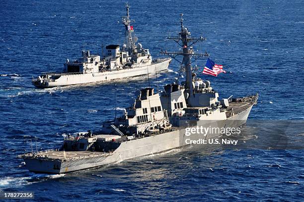 In this handout released by the U.S. Navy, the U.S. Navy guided-missile destroyer USS Barry pulls into formation with the French Marine Nationale...