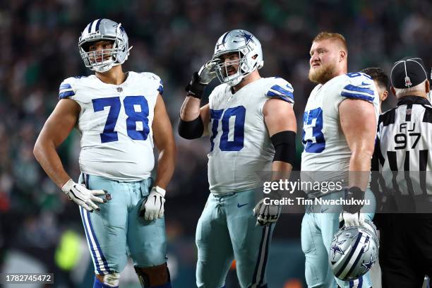 Terence Steele, Zack Martin and Tyler Biadasz of the Dallas Cowboys look on against the Philadelphia Eagles at Lincoln Financial Field on November...