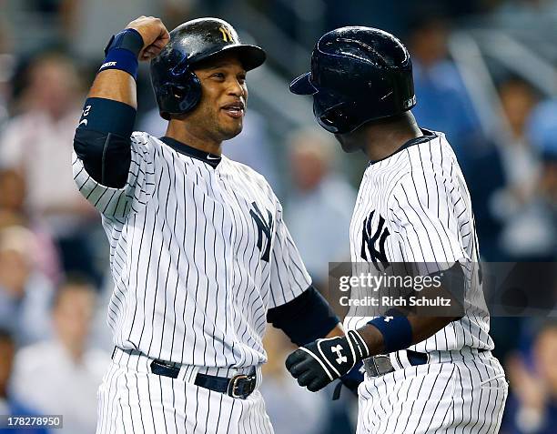 Alfonso Soriano, right, of the New York Yankees is congratulated by teammate Robinson Cano after Soriano hit a two run home run in the eighth inning...