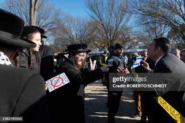 An anti-Zionist Orthodox Jewish protester speaks with a supporter of Israel near where sympathizers of Israel congregated on the Mall near the US...