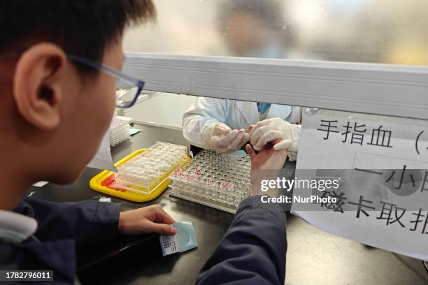 Doctor draws blood from a patient's finger at a hospital emergency department in Shanghai, China, November 14, 2023. Recently, Shanghai seasonal...