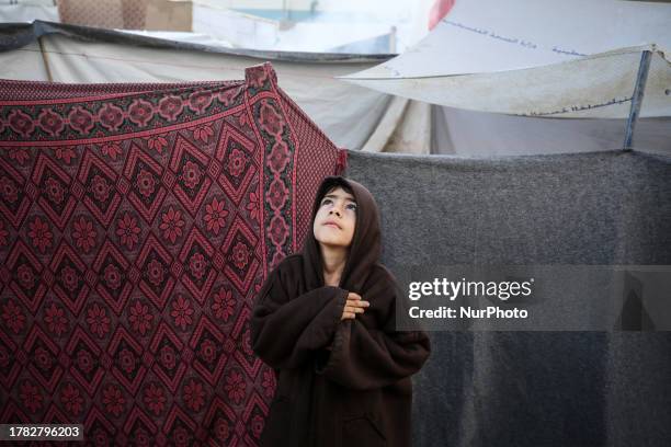 Displaced Palestinians in their camp during a rainy day in Shuhada Al-Aqsa hospital, in Deir el-Balah, in the central Gaza Strip on November 14 amid...