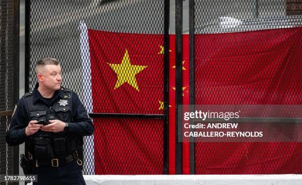 Police officer looks on as supporters await the arrival of China's President Xi Jinping next to Asia-Pacific Economic Cooperation summit headquarters...