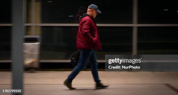 Man walks on a platform at a train station in this slow shutter panning photograph in Warsaw, Poland on 14 November, 2023.