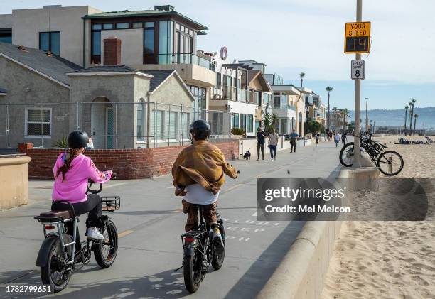 People ride an e-bike on the Strand in Hermosa Beach, going 14 mph, which is over the posted speed limit of 8 mph. In Hermosa Beach, it's against...