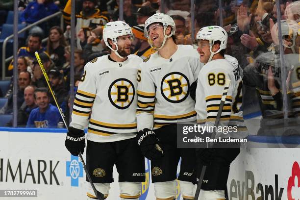 Brandon Carlo of the Boston Bruins celebrates his first period goal with Pavel Zacha and David Pastrnak of the Boston Bruins during an NHL game...