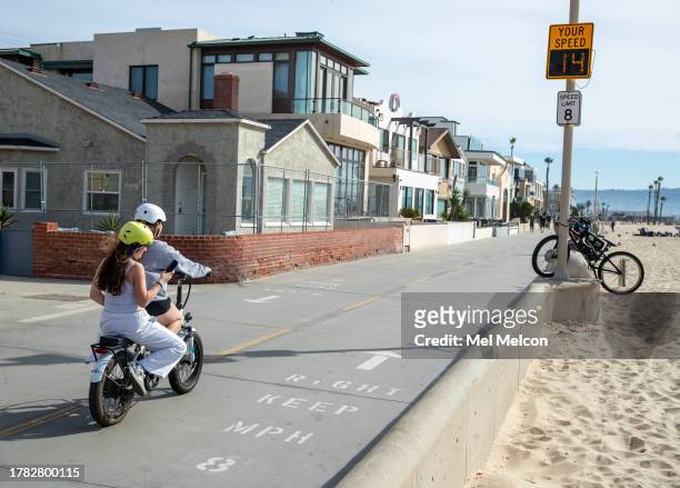 People ride an e-bike on the Strand in Hermosa Beach, going 14 mph, which is over the posted speed limit of 8 mph. In Hermosa Beach, it's against...