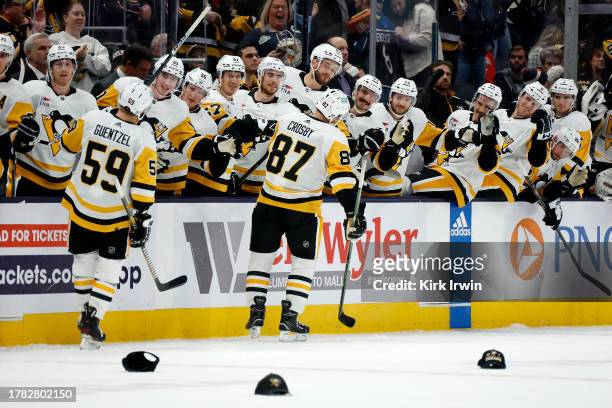 Sidney Crosby of the Pittsburgh Penguins is congratulated by his teammates after scoring his third goal of the game and recording a hat-trick during...