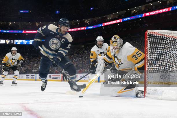 Tristan Jarry of the Pittsburgh Penguins clears the puck away from Boone Jenner of the Columbus Blue Jackets during second period of the game at...