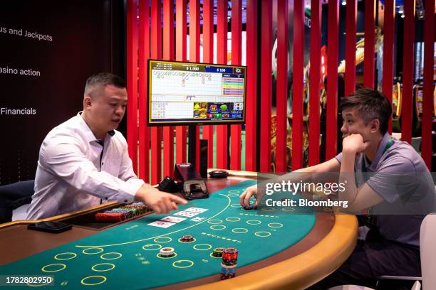 An attendee plays at a baccarat table at the Macau Gaming Show in Macau, China, on Tuesday, Nov. 14, 2023. Macau's casinos have largely stayed on a...