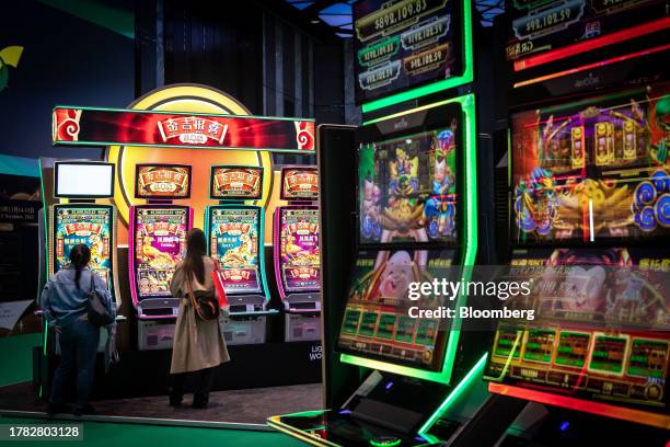 Attendees look at slot machines during the Macau Gaming Show in Macau, China, on Tuesday, Nov. 14, 2023. Macau's casinos have largely stayed on a...