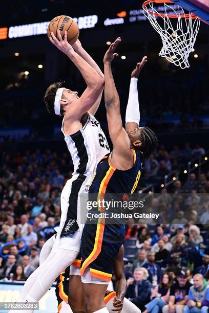 Zach Collins of the San Antonio Spurs puts up a shot while being defended by Jalen Williams of the Oklahoma City Thunder during the second half of an...