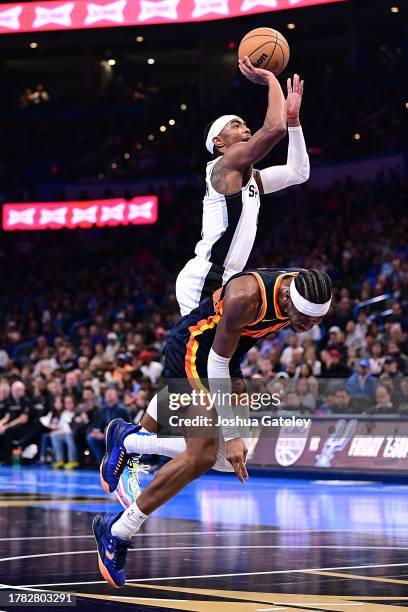 Devonte Graham of the San Antonio Spurs goes up for a shot over Shai Gilgeous-Alexander of the Oklahoma City Thunder during the second half of an NBA...