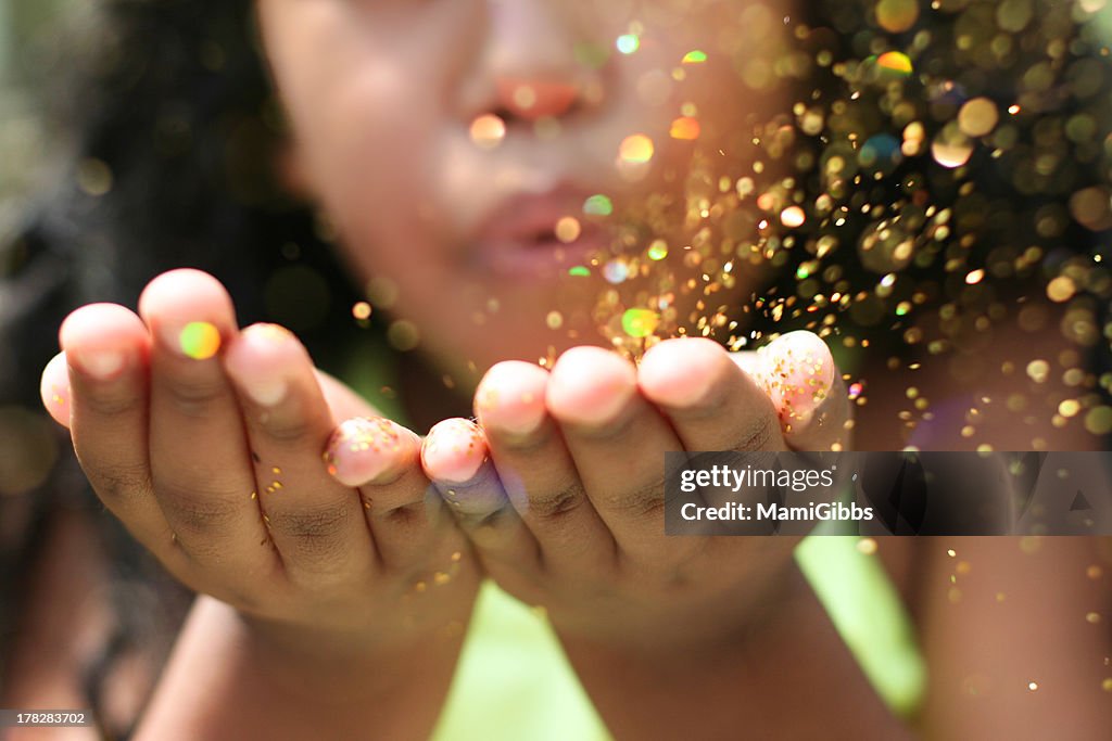 Glitter flies from the hand of the girl