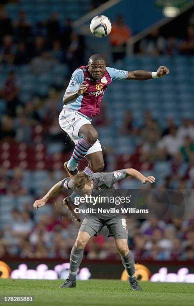 Jores Okore of Aston Villa is challenged by Lee Frecklington of Rotherham United during the Capital One Cup Second Round match between Aston Villa...