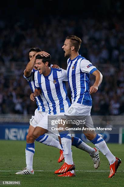 Carlos Vela of Real Sociedad celebrates scoring their opening goal with teammates during the UEFA Champions League Play-offs second leg match between...