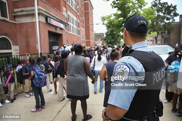 Chicago Probationary Police officer Juan Soto watches as students leave Laura Ward Elementary school on the Westside on August 28, 2013 in Chicago,...