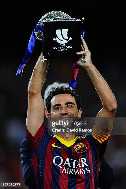 Xavi Hernandez of FC Barcelona holds up the trophy after winning the Spanish Super Cup during the Spanish Super Cup second leg match between FC...