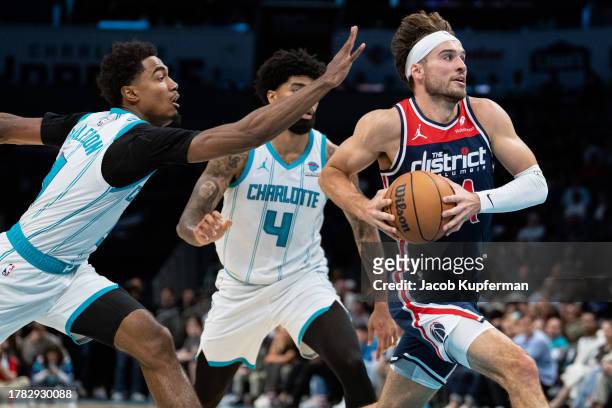 Corey Kispert of the Washington Wizards drives to the basket past Theo Maledon and Nick Richards of the Charlotte Hornets in the second quarter...