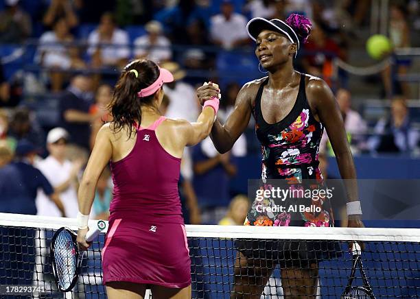 Jie Zheng of China shakes hands at the net with Venus Williams of the United States of America after their women's singles second round match on Day...