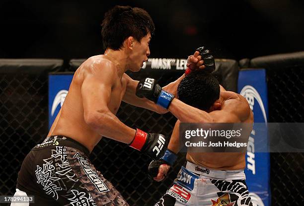 Takeya Mizugaki punches Erik Perez in their bantamweight fight during the UFC on FOX Sports 1 event at Bankers Life Fieldhouse on August 28, 2013 in...