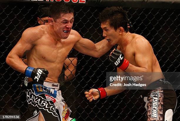 Erik Perez punches Takeya Mizugaki in their bantamweight fight during the UFC on FOX Sports 1 event at Bankers Life Fieldhouse on August 28, 2013 in...