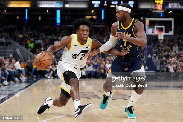 Collin Sexton of the Utah Jazz dribbles the ball while being guarded by Buddy Hield of the Indiana Pacers in the third quarter at Gainbridge...