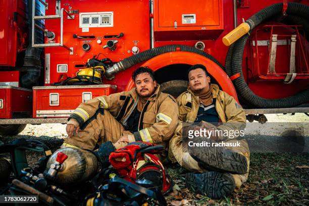 exhausted firefighter resting in fire station - fireman uniform stock pictures, royalty-free photos & images