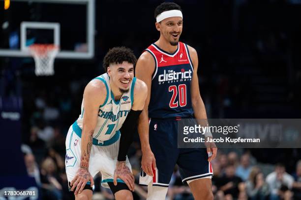LaMelo Ball of the Charlotte Hornets and Landry Shamet of the Washington Wizards react during their game at Spectrum Center on November 08, 2023 in...
