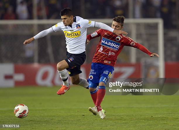 Chilean Colo Colo's footballer Esteban Pavez vies for the ball with Colombian Deportivo Pasto's Juan Villota during their Copa Sudamericana 2013...