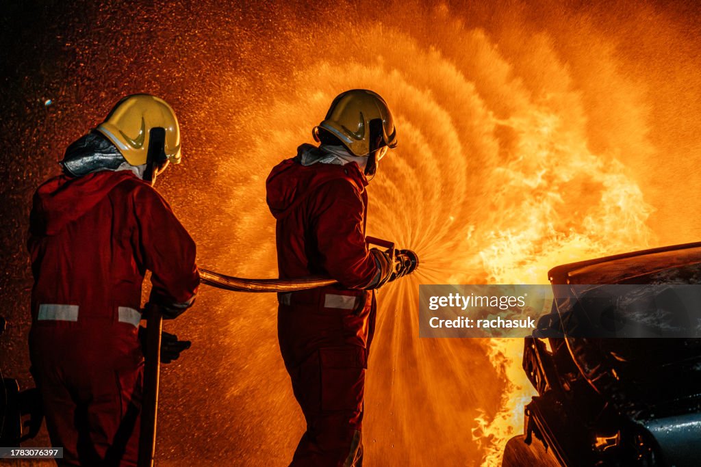 Firefighters fighting car fire