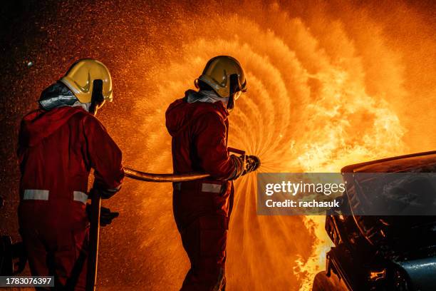 firefighters fighting car fire - car splashing water on people stock pictures, royalty-free photos & images