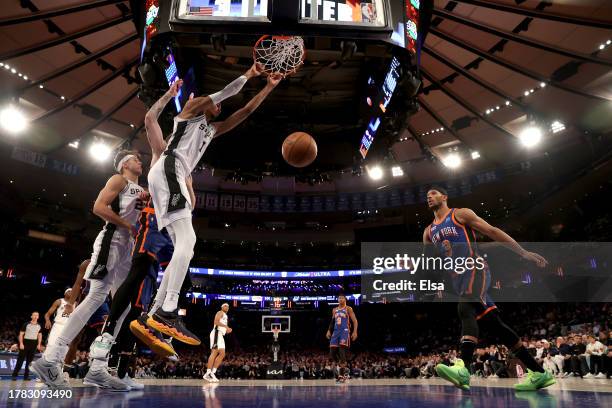 Victor Wembanyama of the San Antonio Spurs dunks the ball against Isaiah Hartenstein of the New York Knicks during the fourth quarter in the game at...