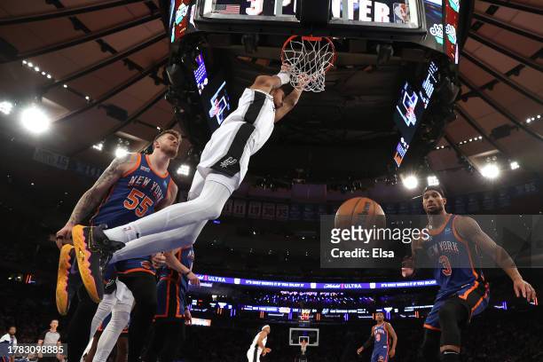 Victor Wembanyama of the San Antonio Spurs dunks the ball against Isaiah Hartenstein of the New York Knicks during the fourth quarter in the game at...
