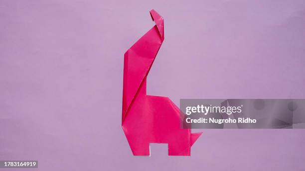 dinosaur origami paper craft on blank background - dinosaur background stock pictures, royalty-free photos & images