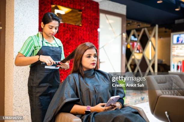 processional hair dresser styling hair of young woman in beauty salon - beauty salon stock pictures, royalty-free photos & images