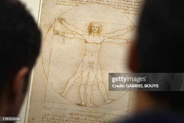 People look at the "Vitruvian Man" a drawing by Leonardo da Vinci, on August 2ç, 2013 in Venice. Fifty-two drawings by Renaissance genius Leonardo da...