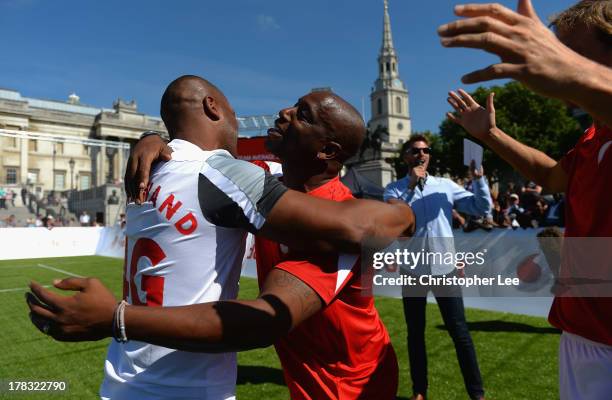 Ex Arsenal Legend Ian Wright hugs Ex Tottenham Hotspur legend Les Ferdinand as Arsenal celebrate their victory during the Vodafone 4G Goes Live...