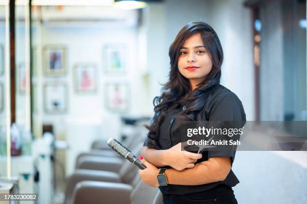 porträt einer jungen friseurin im salon - modestylistin stock-fotos und bilder