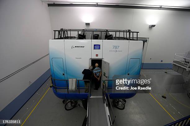 Visitors look in on one of the full-flight simulators for the 787 Dreamliner on August 29, 2013 in Miami, Florida. The simulator is in the newly...