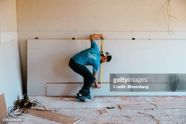 Contractor uses a tape measure at a home under construction at the Cold Spring Barbera Homes subdivision in Loudonville, New York, US, on Wednesday...
