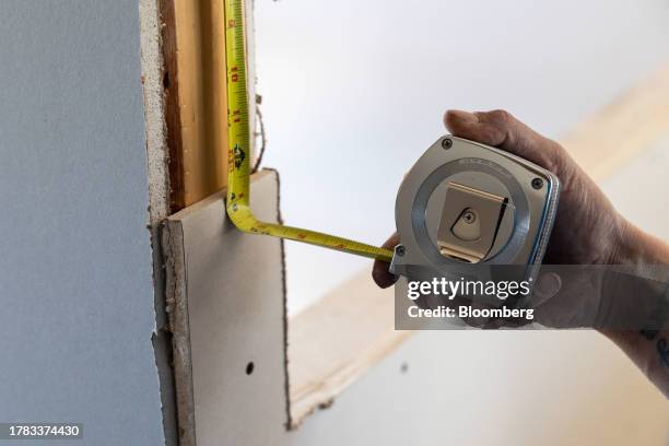 Contractor uses a tape measure at a home under construction at the Cold Spring Barbera Homes subdivision in Loudonville, New York, US, on Wednesday...