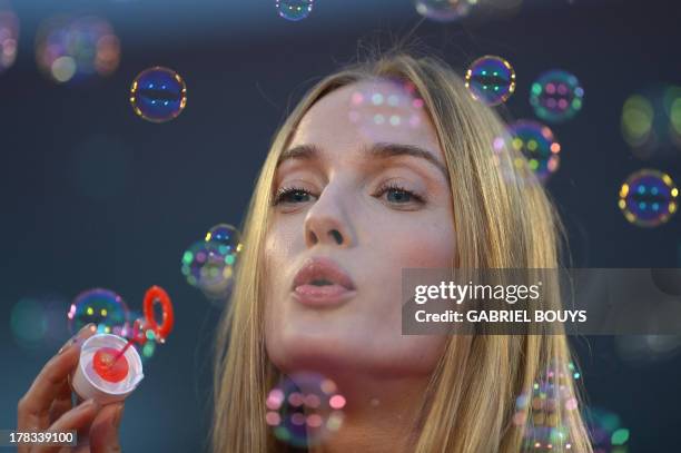 Italian model Eva Riccobono makes soap bubbles on the red carpet before for the screening of "Tracks" presented in competition at the 70th Venice...