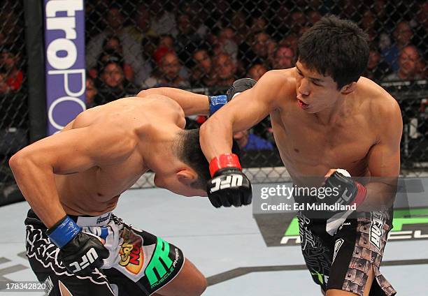 Takeya Mizugaki punches Erik Perez in their bantamweight fight during the UFC on FOX Sports 1 event at Bankers Life Fieldhouse on August 28, 2013 in...