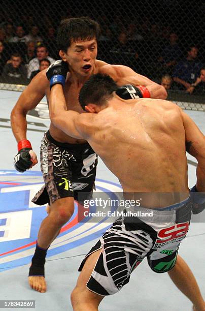 Takeya Mizugaki punches Erik Perez in their bantamweight fight during the UFC on FOX Sports 1 event at Bankers Life Fieldhouse on August 28, 2013 in...